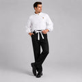 May include: A white long-sleeved shirt with a high collar and an asymmetrical button closure paired with black trousers featuring a white tie-waist belt. The shirt has full sleeves and the trousers are straight-legged with a clean, tailored finish.