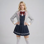 May include: A school uniform set consisting of a light gray blazer with pink lapel trim, a white collared shirt, a dark navy blue vest with gold buttons, a matching pleated navy blue skirt with white stripes, a dark red bow tie, and white socks.