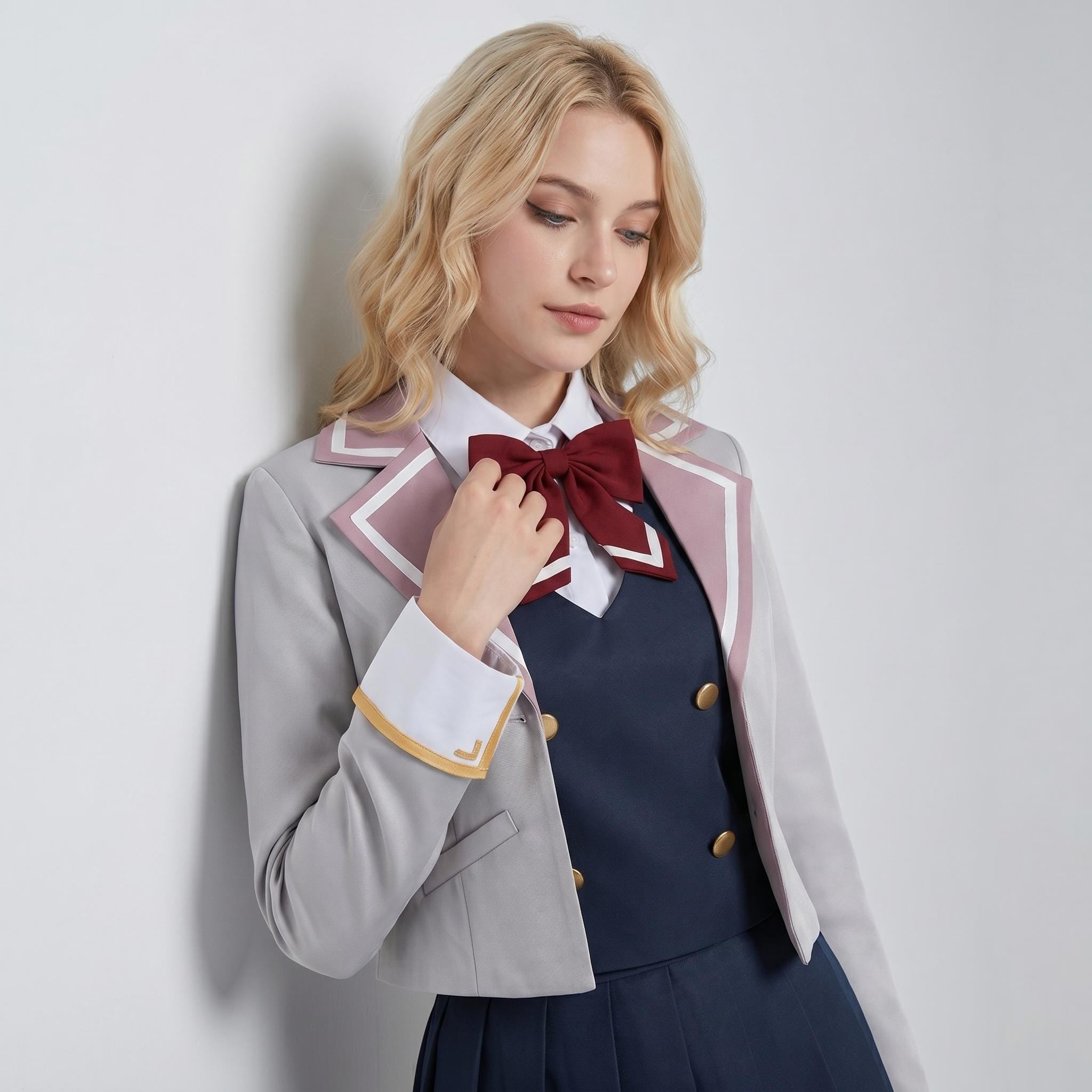 May include: A light gray cropped blazer with mauve lapel trim and white piping, worn over a navy blue double-breasted vest with gold buttons. A crisp white collared shirt is underneath, accented by a dark red bow tie and a pleated navy skirt.