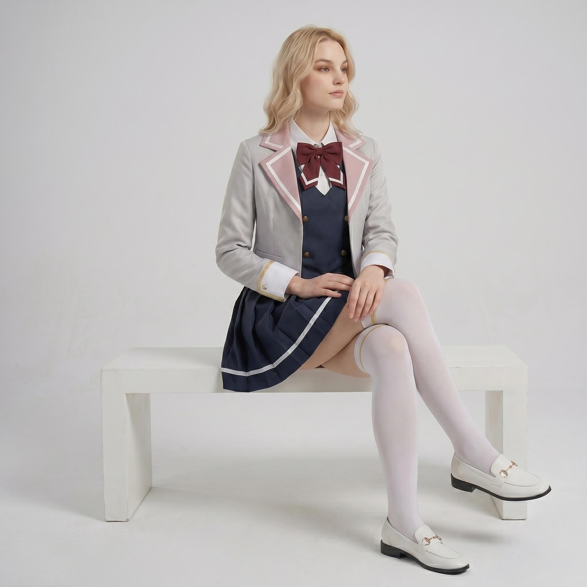 May include: A light gray blazer with pink lapel trim, a dark blue sleeveless dress with a white collar, and a maroon bow tie. The outfit includes a pleated dark blue skirt with a white hem stripe, white over-the-knee socks, and white loafers.