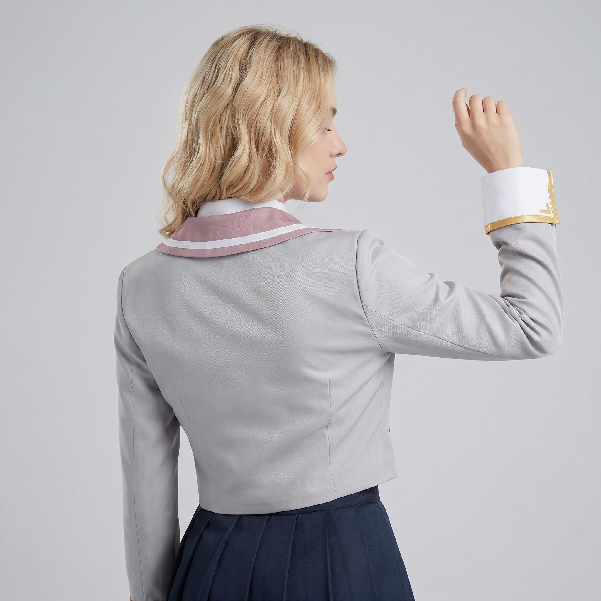 May include: A light gray cropped jacket featuring a mauve sailor-style collar with a white trim, long sleeves with wide white cuffs accented by a gold border, and a dark navy blue pleated skirt worn underneath the jacket.