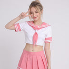 May include: A white cropped sailor-style top featuring a pink collar with two white stripes, short sleeves with matching pink cuffs, and a pink neck scarf. The outfit includes a matching pink pleated mini skirt with two white stripes at the hem.