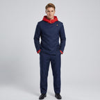 May include: A dark blue long-sleeved jacket with a bright red hood and matching red sleeve cuffs, featuring a high collar with a single gold button closure. The jacket is paired with matching dark blue trousers and black dress shoes.