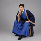 May include: A layered ensemble featuring a bright blue inner robe and a dark navy blue outer robe with wide sleeves. The outer robe is trimmed with a tan patterned border. A dark blue sash is tied at the waist over a white collar base layer.