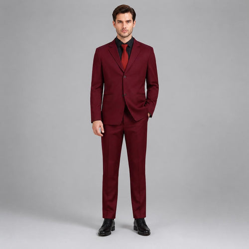 May include: A deep burgundy two-piece suit consisting of a single-breasted blazer with two buttons and matching trousers. The blazer features notched lapels and is worn over a black button-down shirt with a solid red necktie and black dress shoes.