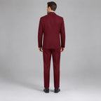 May include: A solid burgundy suit consisting of a single-breasted blazer with a notched lapel and matching trousers. The suit is shown from the back, featuring a clean, tailored fit with a center vent on the jacket and straight-leg pants.