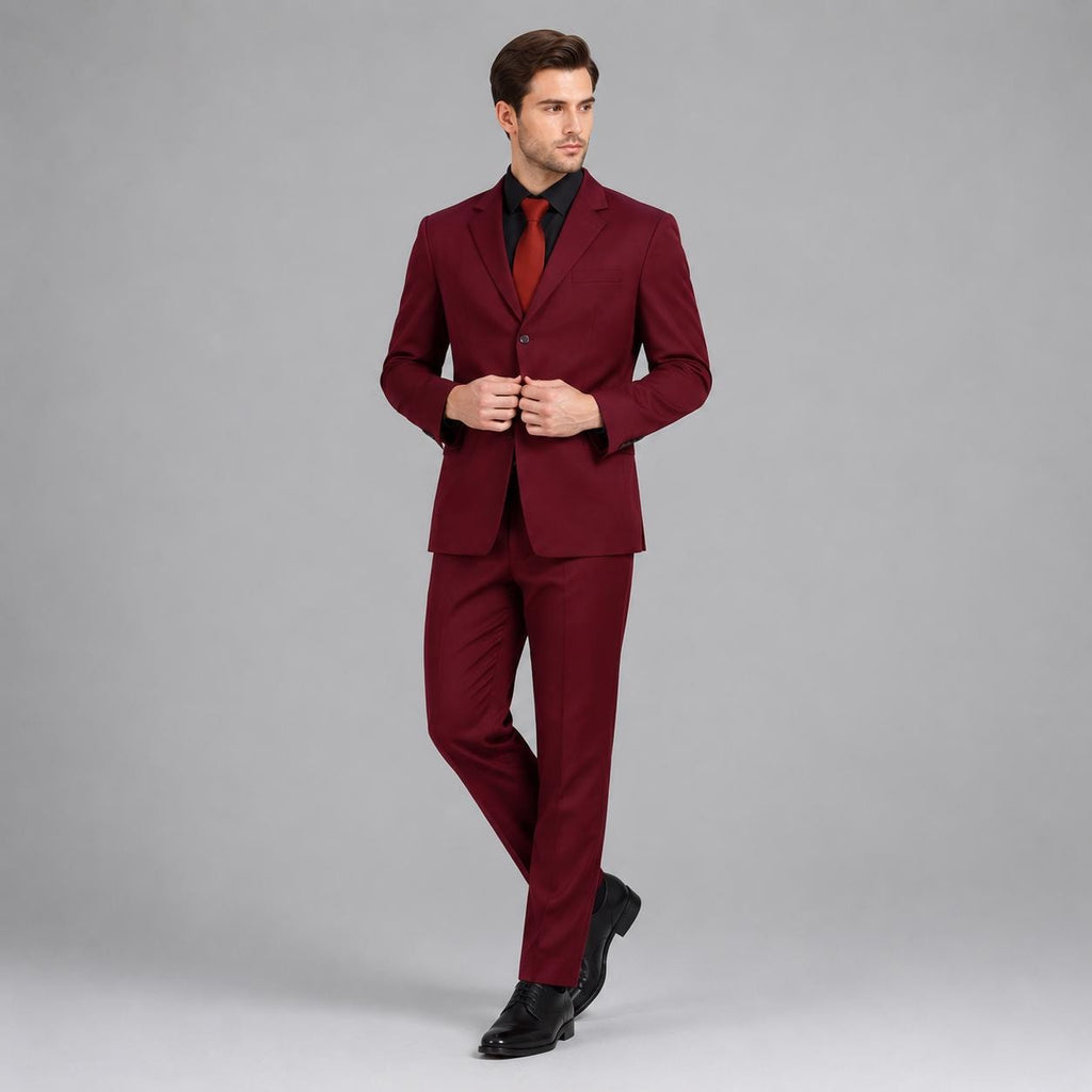 May include: A deep burgundy suit consisting of a single-breasted blazer with notched lapels and matching trousers. The blazer features a single button closure and is paired with a solid red necktie and a crisp white collared dress shirt.
