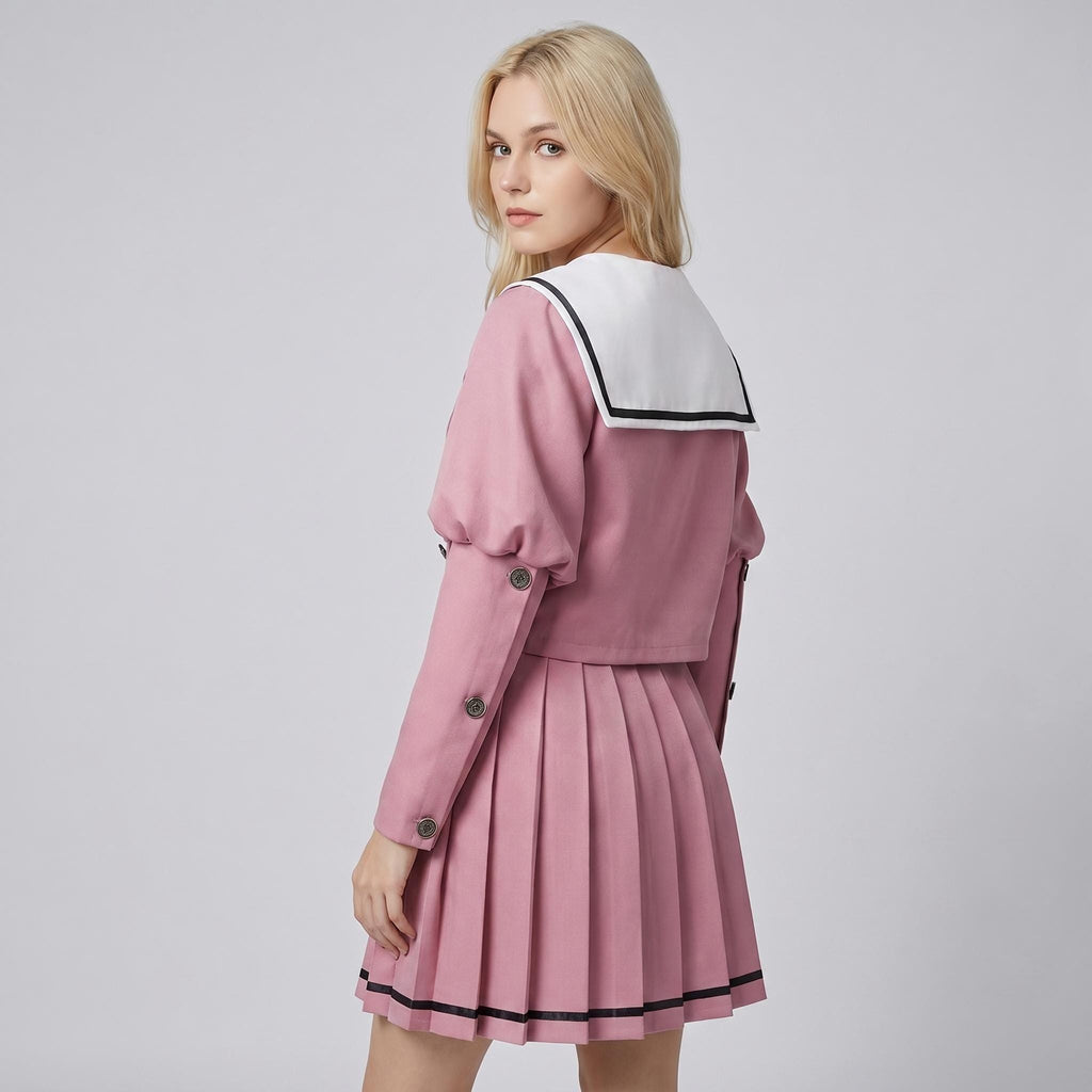 May include: A dusty pink two-piece set consisting of a long-sleeved cropped jacket and a pleated skirt. The jacket features a white sailor-style collar with black trim and buttons along the sleeves. The skirt has a black horizontal stripe at the hem.