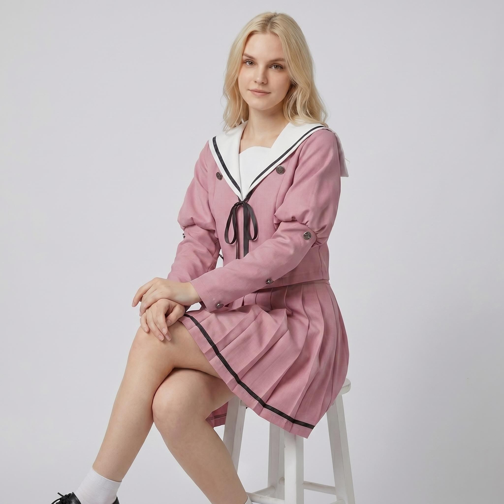 May include: A dusty rose two-piece set consisting of a long-sleeved jacket and a pleated skirt. The jacket features a white sailor-style collar with black trim, a black ribbon tie at the center, and dark buttons along the front and sleeves.